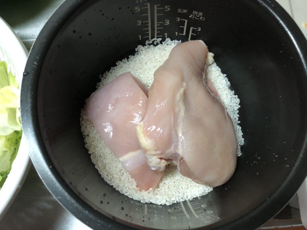 炊飯釜に米と鶏むね肉を入れる